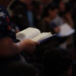 man in black and red shirt reading book